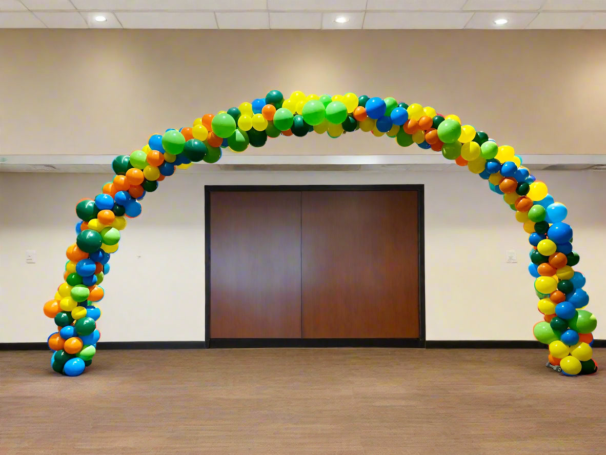Colorful organic balloon arch in a conference room with tables and chairs.